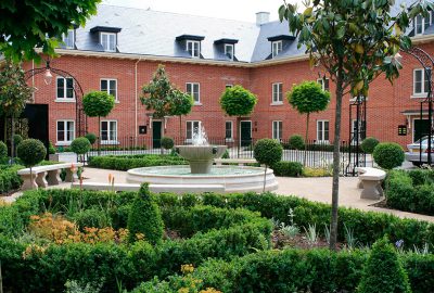 Water fountain surrounded by paving and shrubs