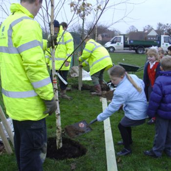 Community tree planting with child planting tree