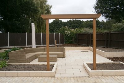 Paved area in garden with wooden entrance
