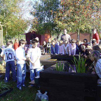 Peaceful Paradise Wildlife Garden with school children looking into planting pot
