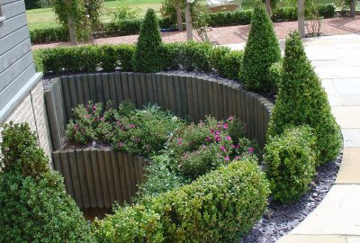 Soft landscaping with bushes and wooden entrances